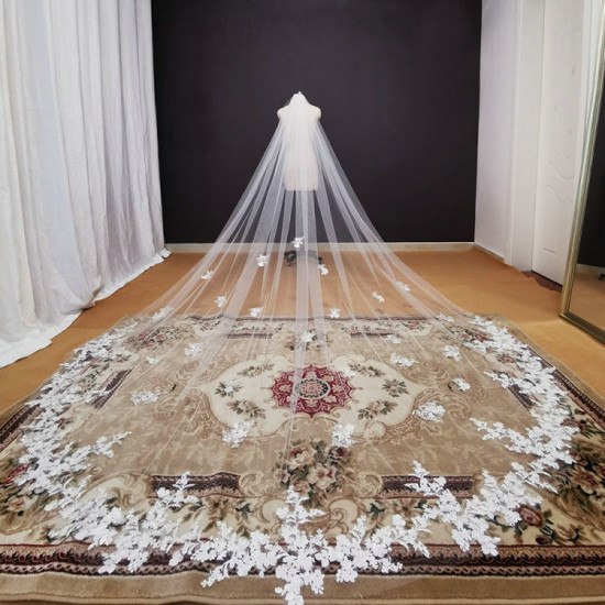 A long embroidered tulle wedding veil from Koshin adorned with flowers and lace in a modern design